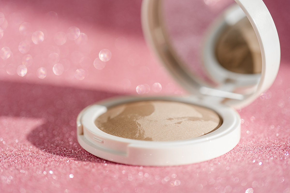 Beige blush on a pink shiny background.